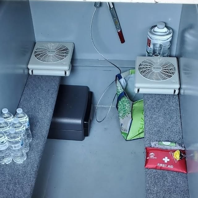 Organized storm shelter with labeled supplies, fans, and first aid kit